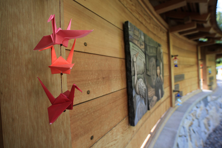View of memorial wall with paper cranes left by visitors.  